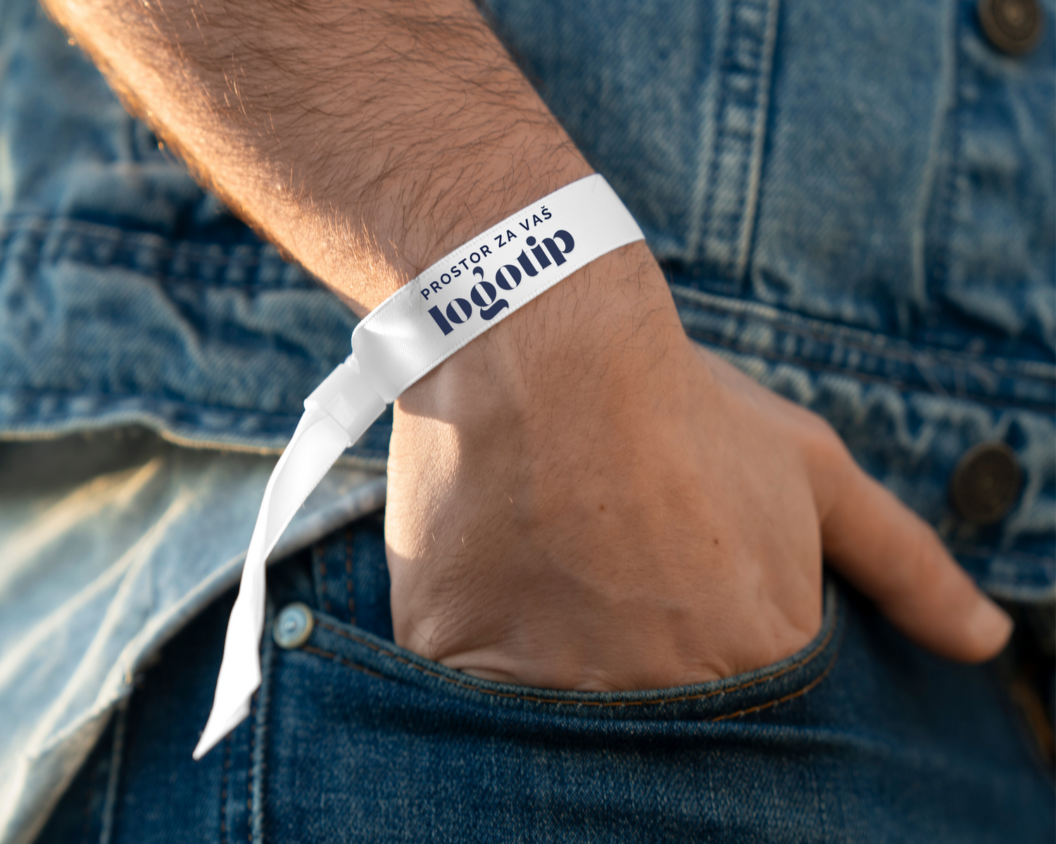 Tekstilna festivalska zapestnica bele barve s tiskom po meri z napisom 'prostor za vaš logotip' na moškem zapestju.